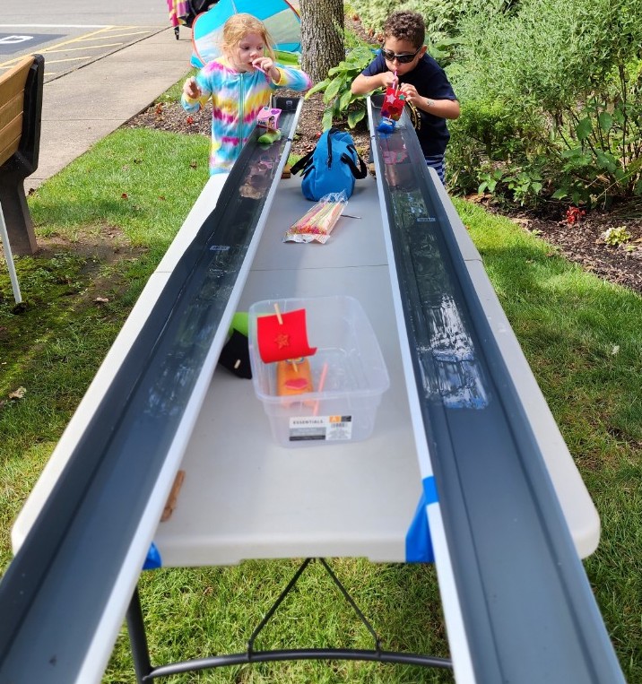 photo of cub scouts female and male participating in the Raingutter Regatta with homemade boats