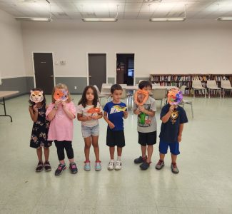 Cub Scouts - male and female - holding orange paper lion masks